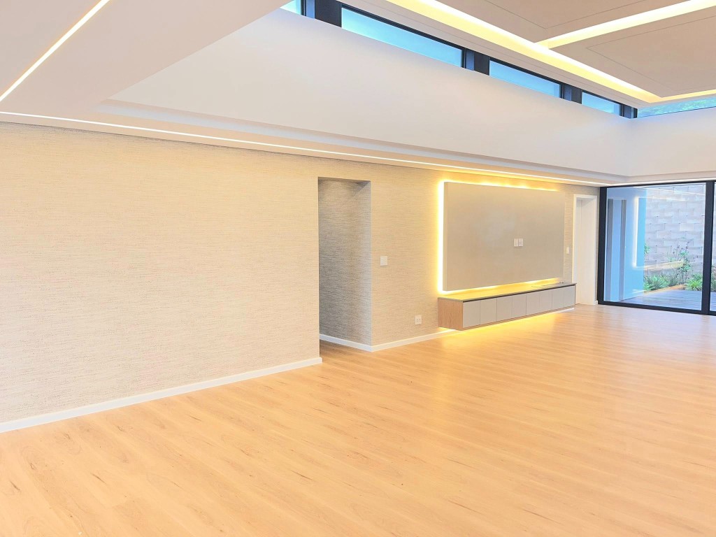 Minimal interior with floor-to-ceiling neutral textured wallpaper and architectural lighting