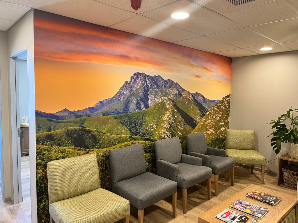 Waiting room with panoramic mountain sunset wallpaper mural and seating